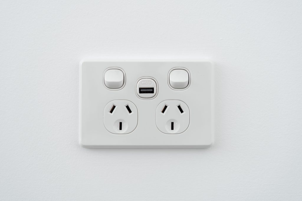 Socket with usb interface and switch on white wall